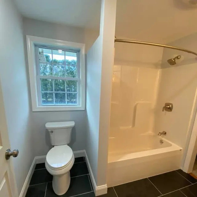 Renovated bathroom with new tub surround and tile floor