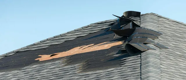 Storm-torn shingles on a Massachusetts roof