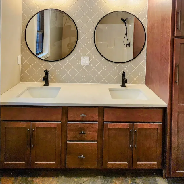 A bathroom with two sinks and two mirrors