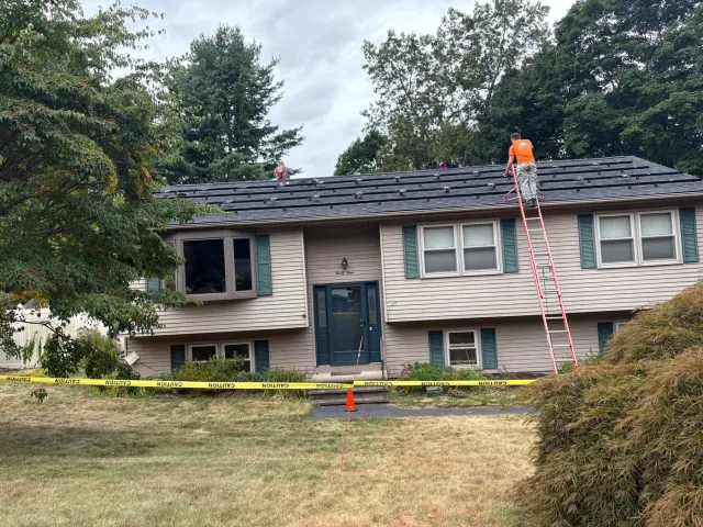 Solar installation crew setting roof racking on a residential home