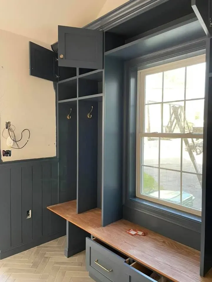 A room with a window and a bench with drawers underneath it.