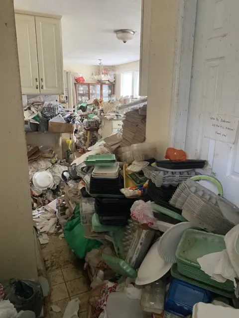 Kitchen packed with junk and debris blocking passage