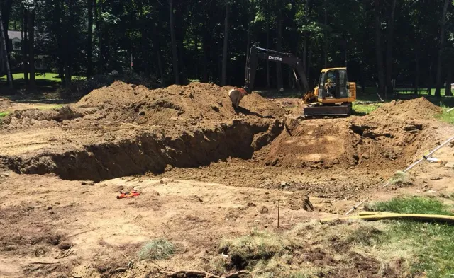 A bulldozer is digging a hole in a dirt field.