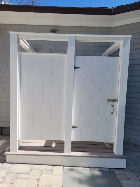 A white shed with a door that is open