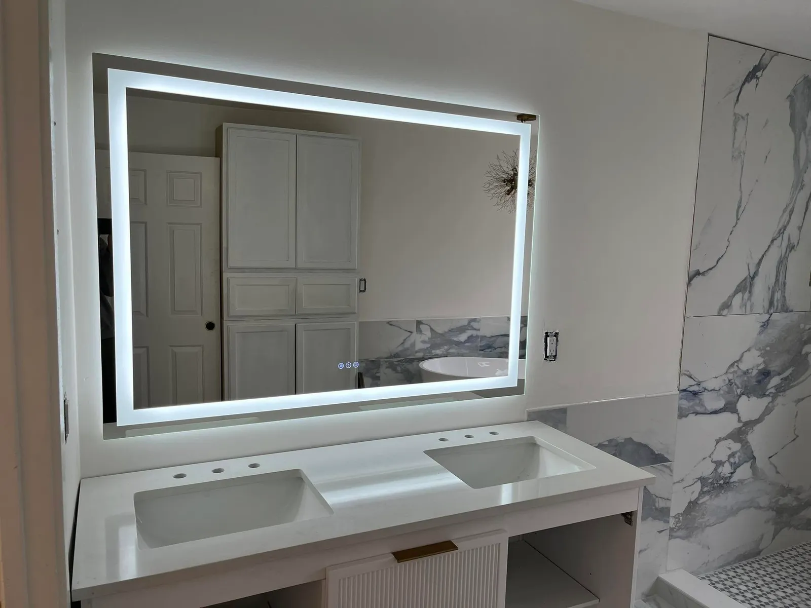 Backlit LED vanity mirror installed in a renovated bathroom