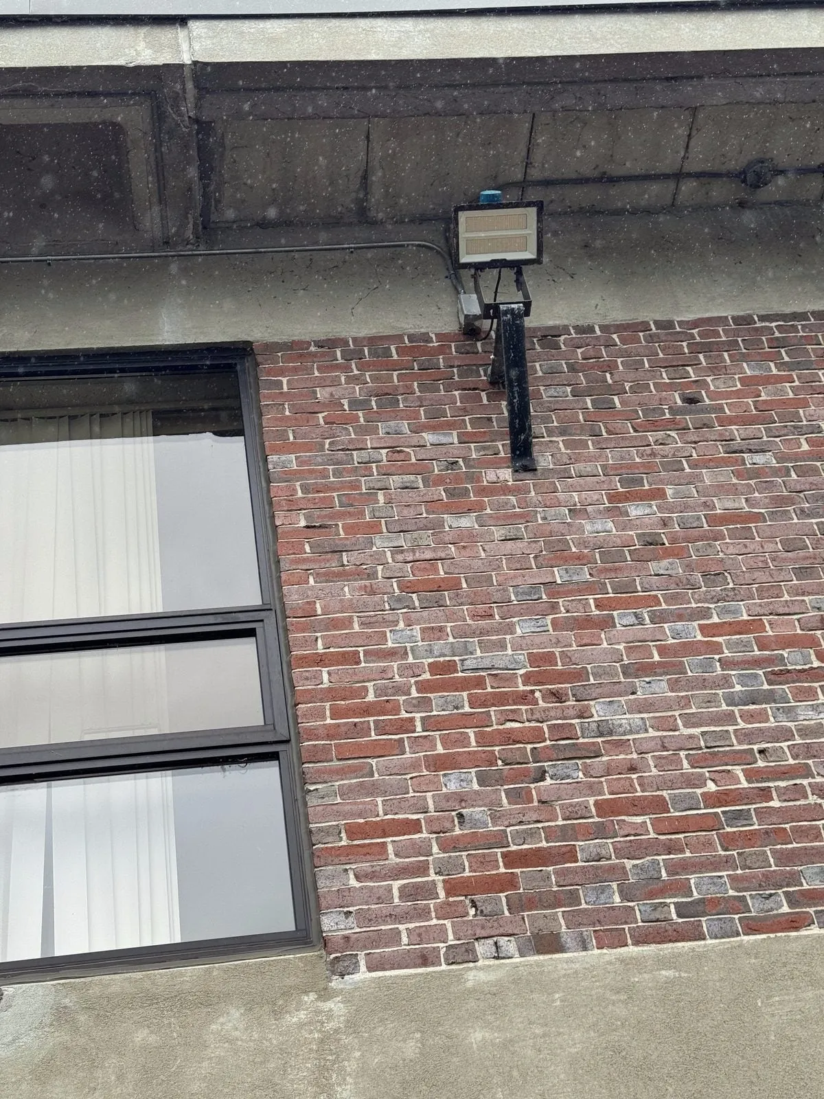 Exterior flood light mounted on brick building