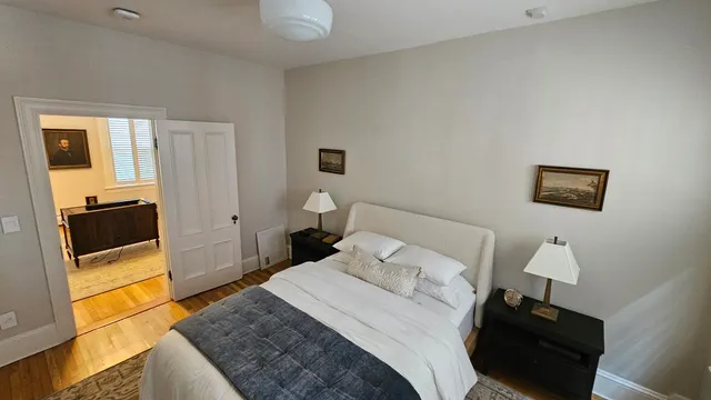 Restored bedroom in a historic Providence condo with refinished hardwood and new trim by Toensing Construction