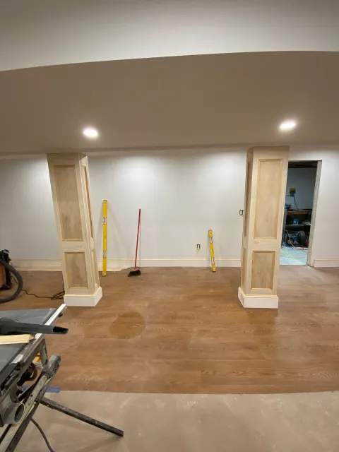 A basement with wooden columns and a wooden floor