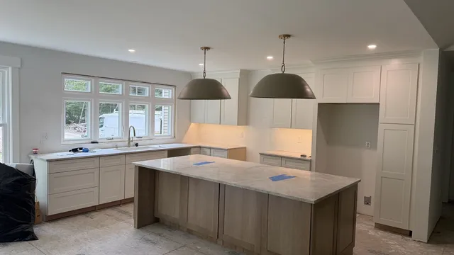 Finished new-build kitchen with recessed lights and pendant lights over the island