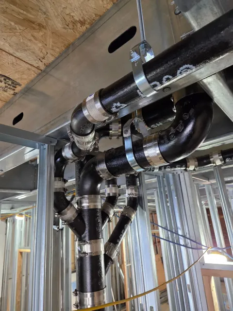 Cast-iron rough plumbing installed within a framed construction project