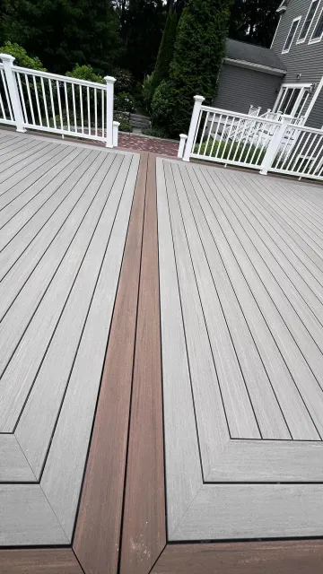 Deck with a dark wood inlay, surrounded by white railings.