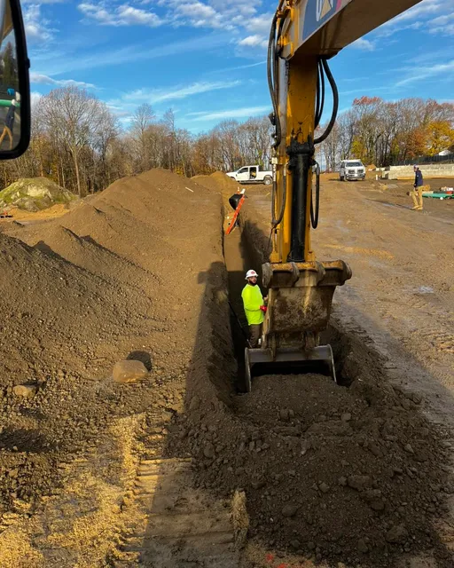 Excavator digging trench for underground utility installation