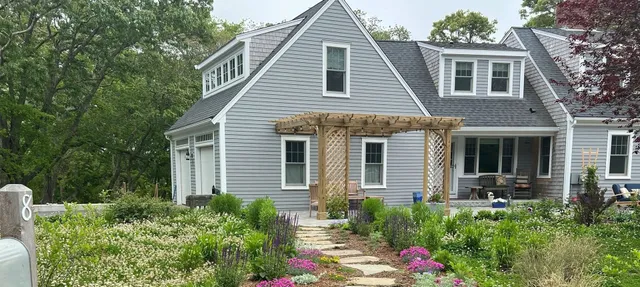 A house with flowers in the front yard.