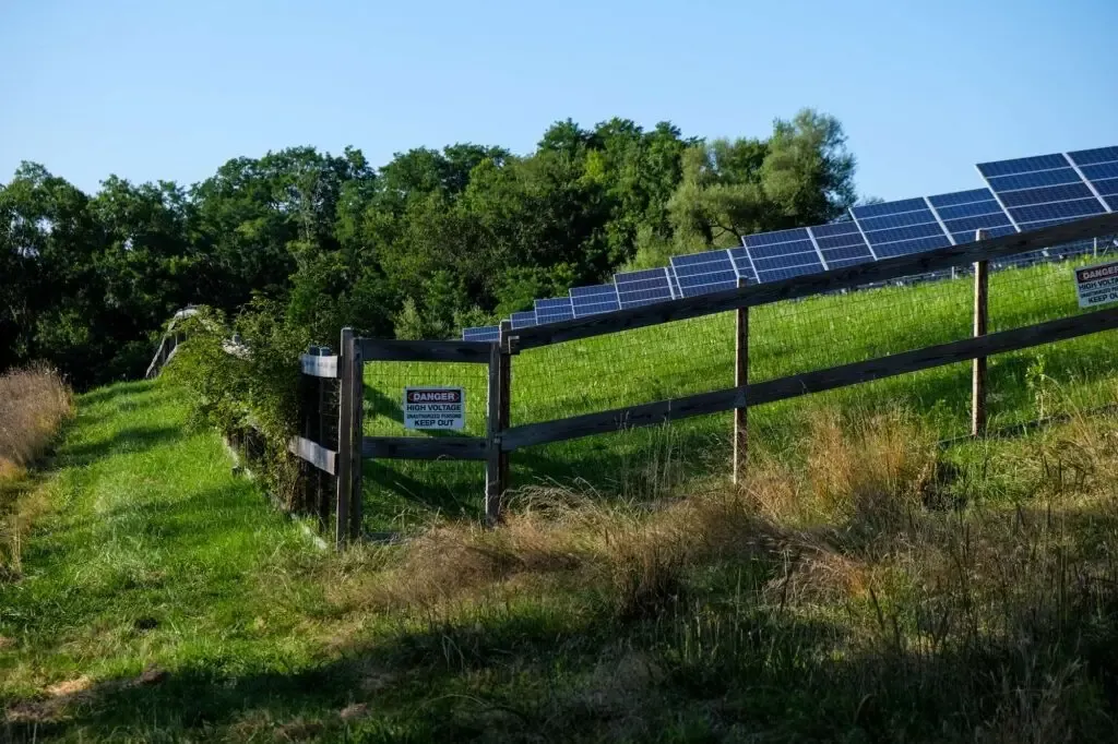 Olympic Fence Company wood fence installation near solar panels in the North Shore, Massachusetts.