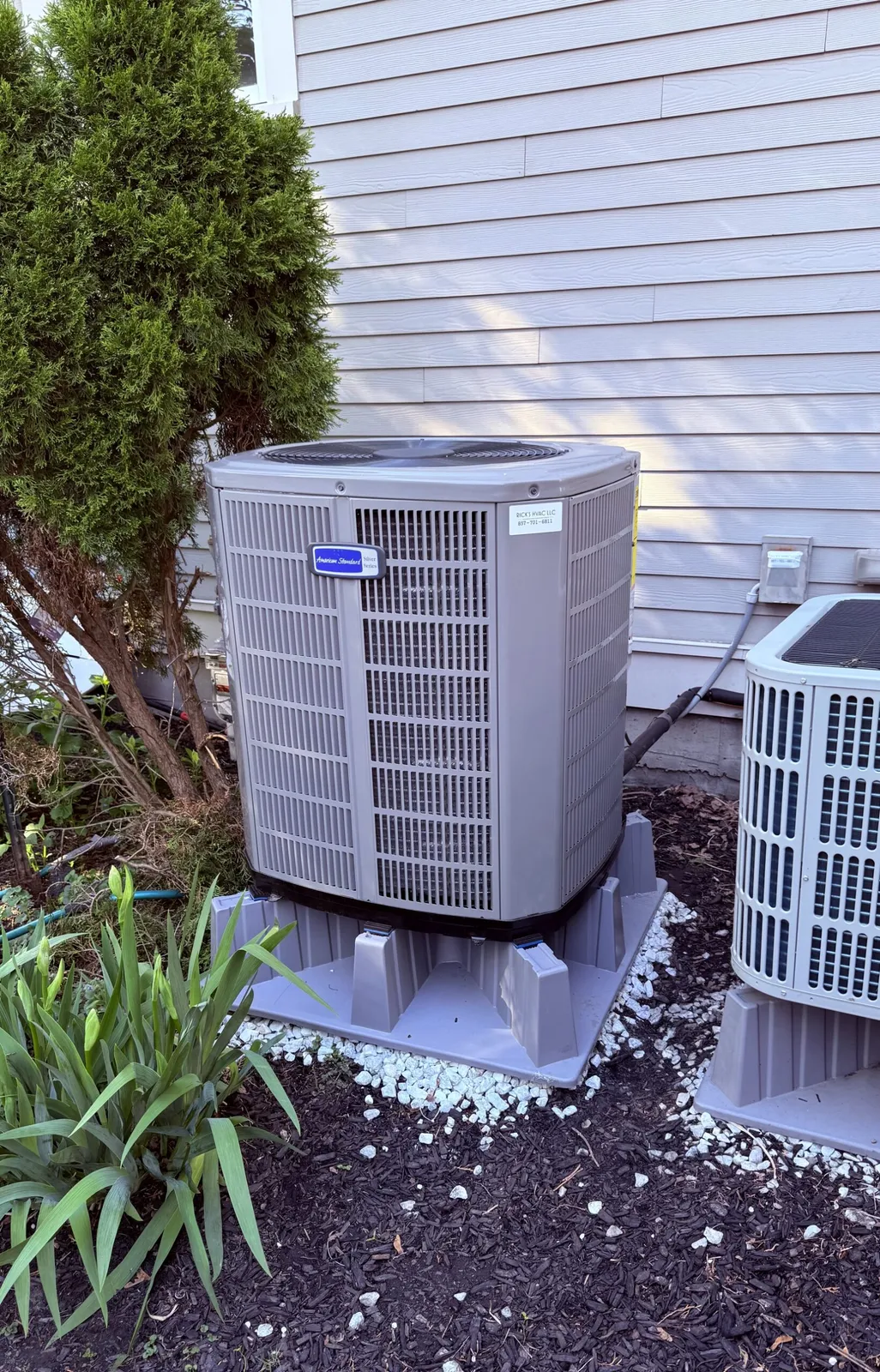 Outdoor HVAC condenser unit beside house siding