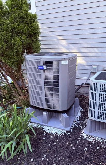 Outdoor HVAC condenser unit beside house siding