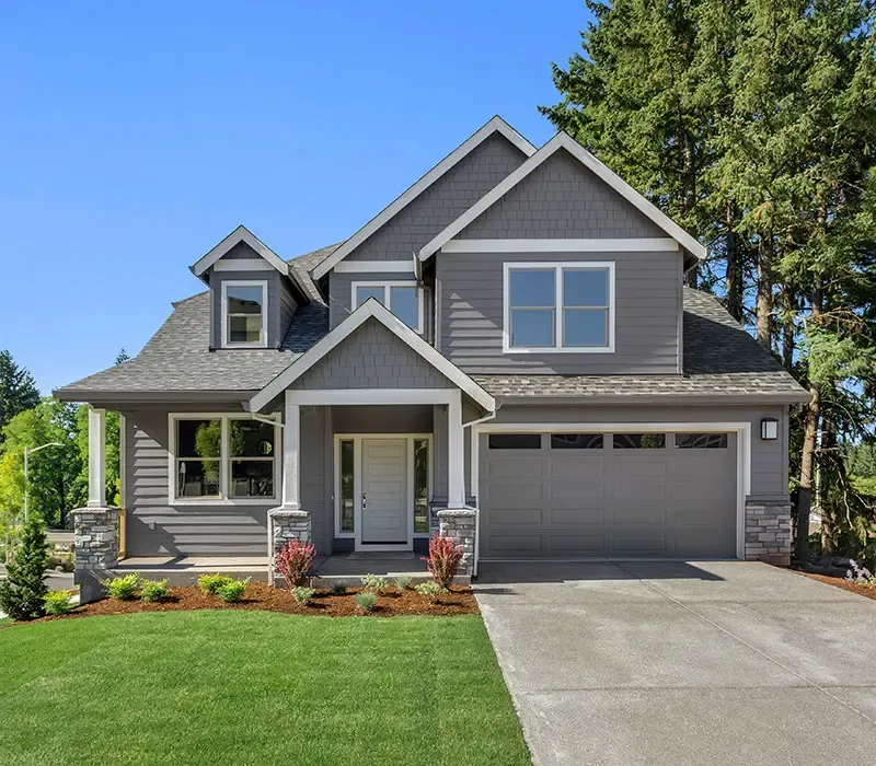 Grey house with bright green grass that has Catseye Platinum Home Protection to protect against pests