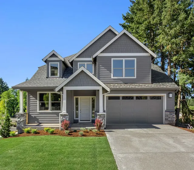 Grey house with bright green grass that has Catseye Platinum Home Protection to protect against pests