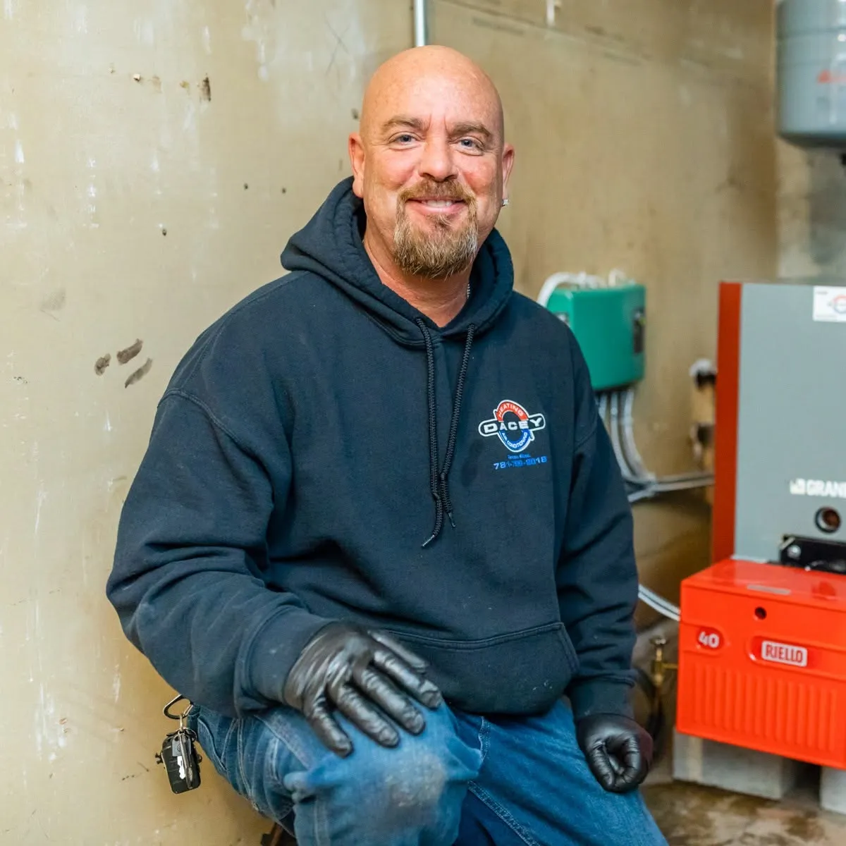 Dacey technician beside an installed oil burner and boiler