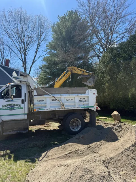 Excavator and dump truck at a residential job site