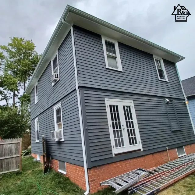 A gray house with a ladder in front of it