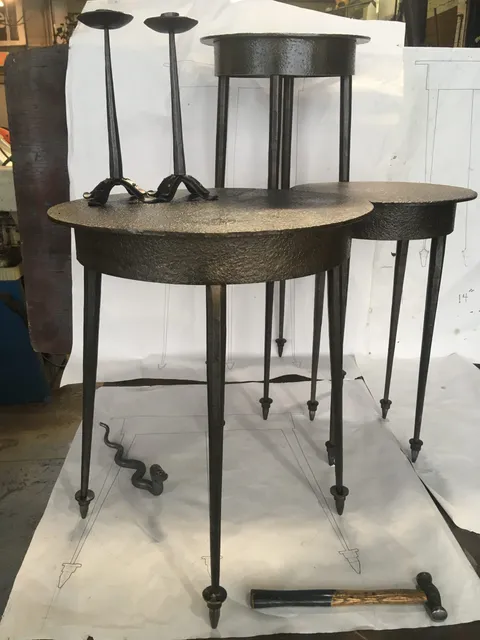 Set of forged metal end tables with round tops on tapered legs
