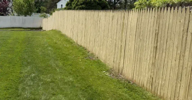 Tall wood privacy fence installed along a backyard property line
