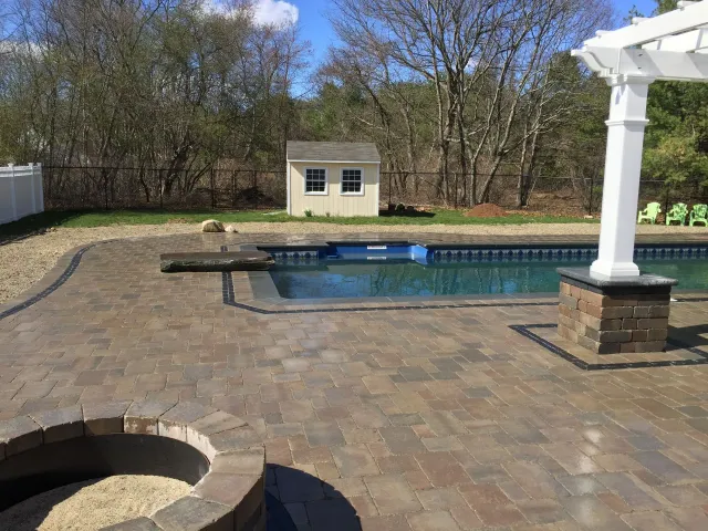 A patio with a fire pit and a swimming pool