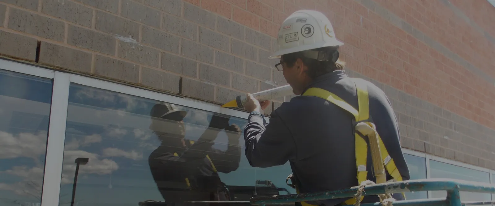 man re-caulking window