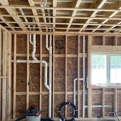 New construction plumbing with exposed stud walls, PVC drain lines, and copper supply piping by Top Tier Plumbing & Heating LLC