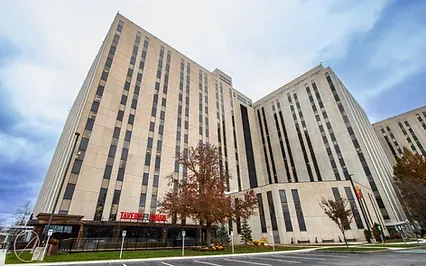Exterior of a large commercial office building serviced by facility maintenance teams, featuring tall vertical windows and a