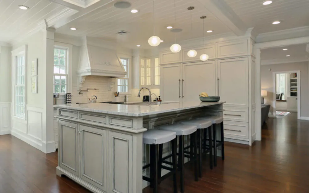 Photo of kitchen with white cabinets and large island - Woodland Builders, South Shore MA.