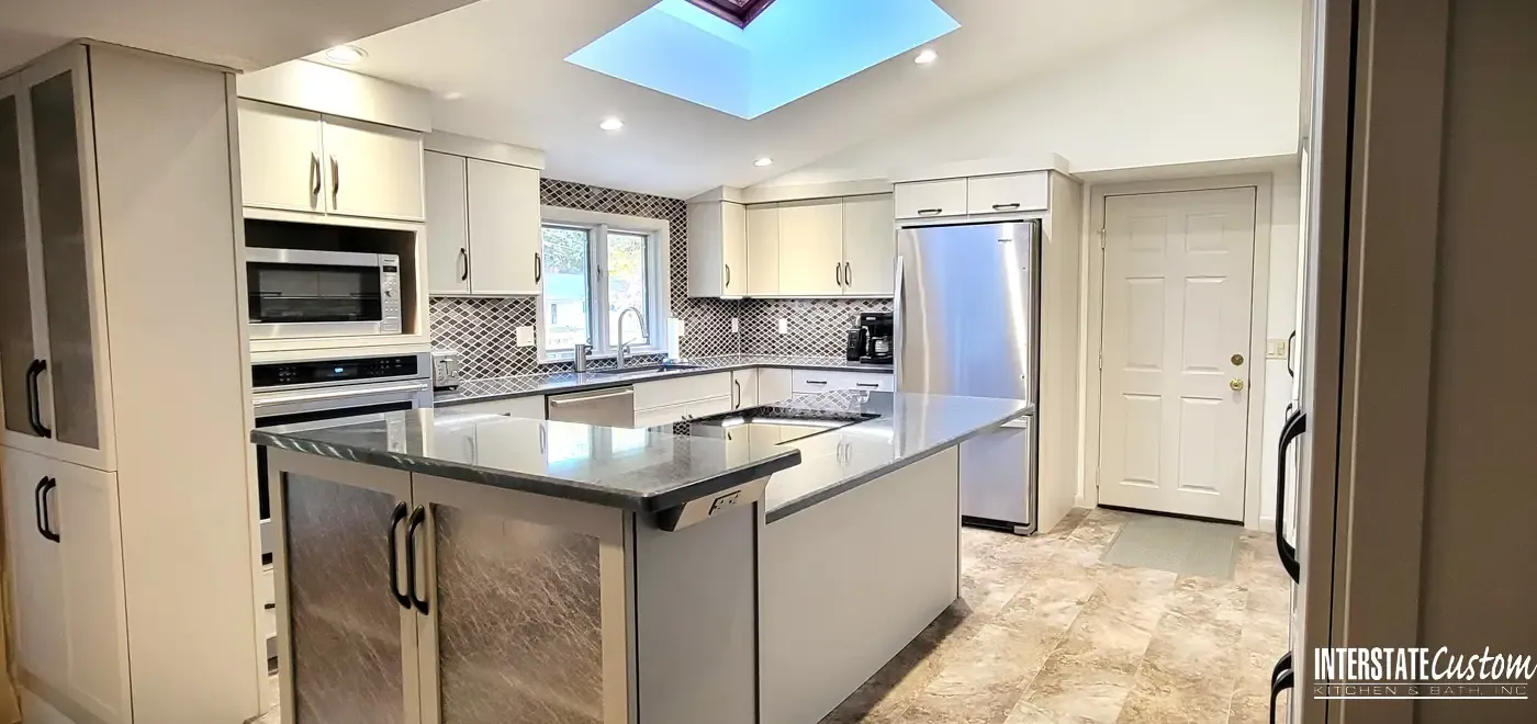 Bright and open kitchen design with a large island, stainless steel appliances, and a skylight bringing in natural light.