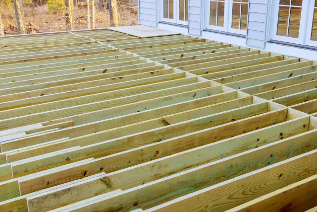 Deck builder in New Hampshire framing a composite deck
