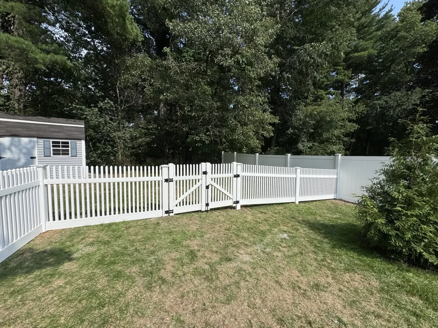 White vinyl picket fence with double gates and privacy panels