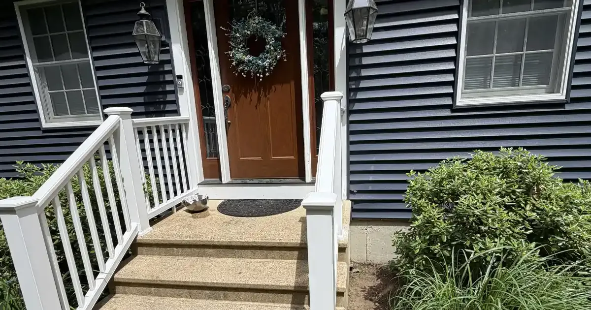 New white vinyl railing installed on a front entry staircase leading to a home's front door