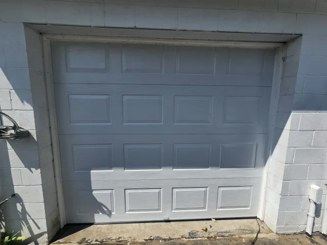 New white raised-panel garage door installed in the same opening