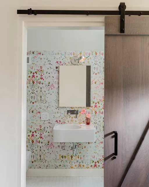 A bathroom with a wooden door and a sink