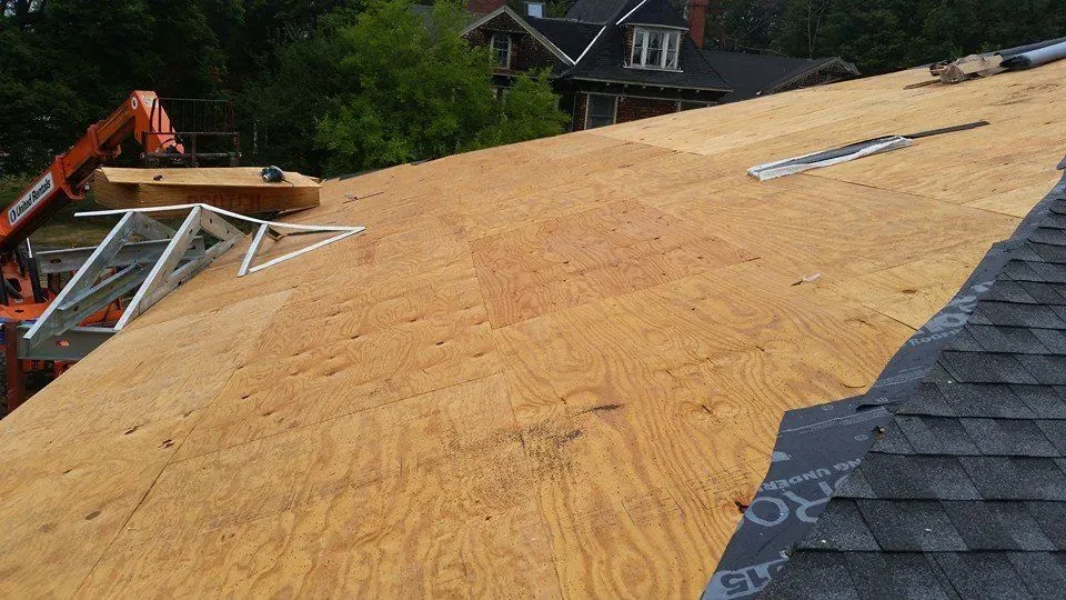 A roof is being built with plywood and shingles.