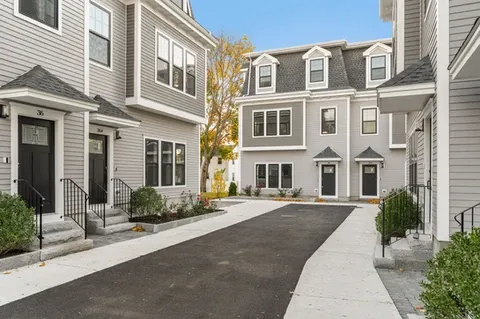 Entrance of the development with the facades of the townhouses displayed.