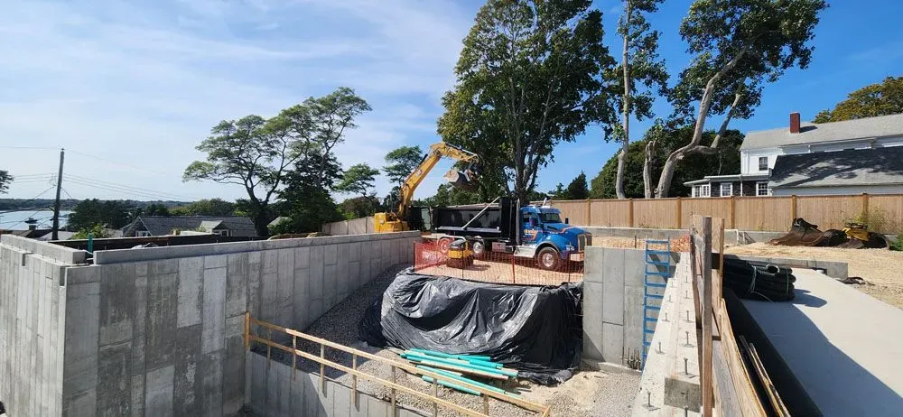 A large concrete wall is being built next to a body of water.