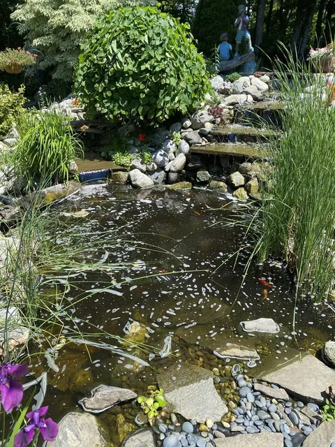Custom water feature with natural stone landscaping in Central Massachusetts