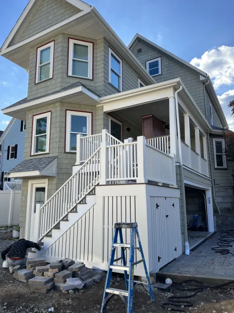 A house with stairs and a ladder in front of it