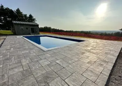 In-ground swimming pool with concrete floor around it - fiberglass pools hampstead nh