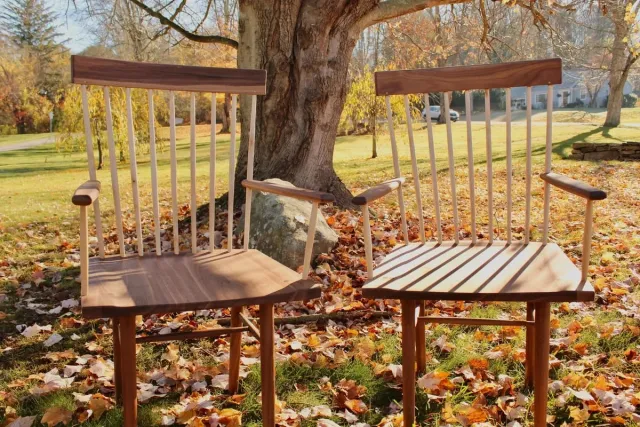 Pair of handcrafted wood chairs under tree with autumn leaves outside a Central Connecticut home by Riverbend Renovations