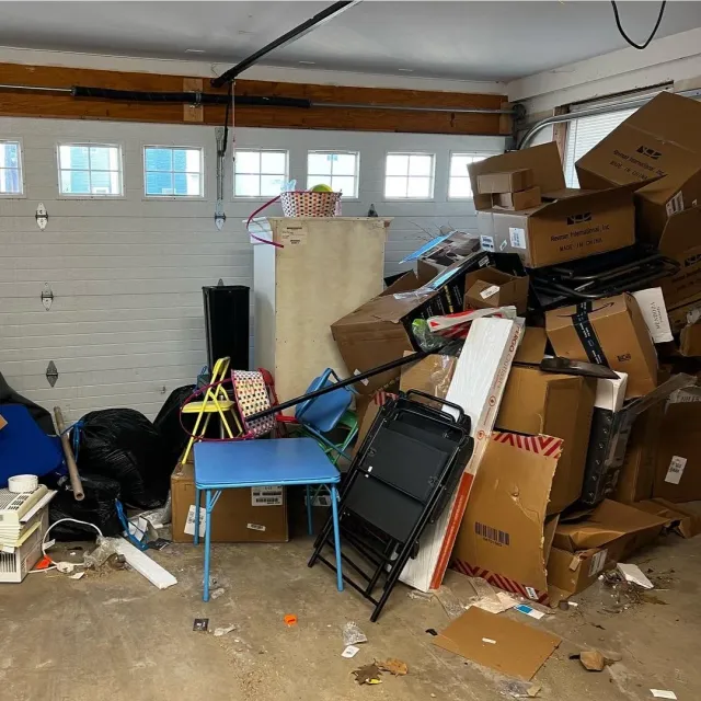 A pile of junk in front of a white garage door.