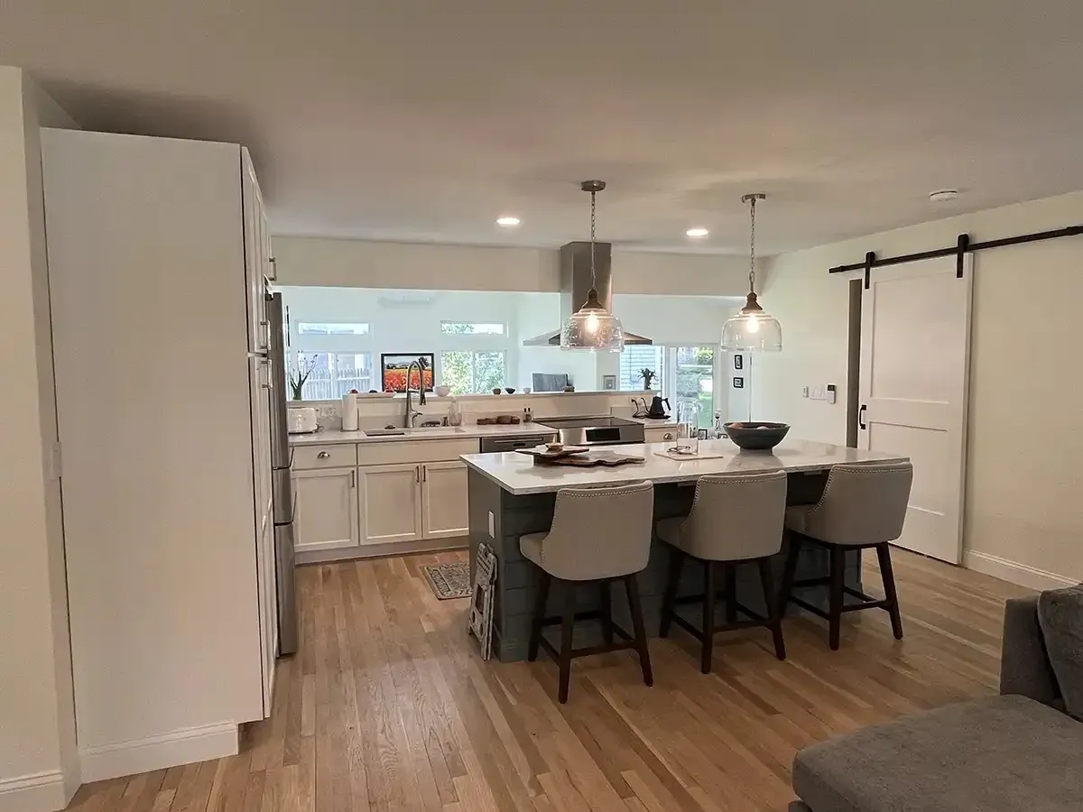 Open-plan kitchen remodel with island seating and barn door