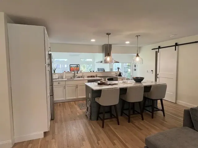 Open-plan kitchen remodel with island seating and barn door