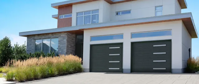 Two Standard+ Vog garage doors (10×8, Iron Ore) with slim white sandblasted windows. Installed in Lincoln, RI by Quality Overhead Doors