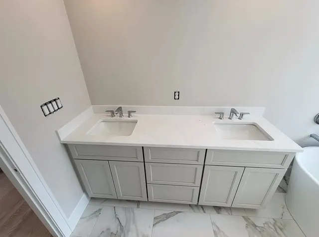 Double vanity with two sinks and chrome faucets installed by Aroso Plumber Methuen